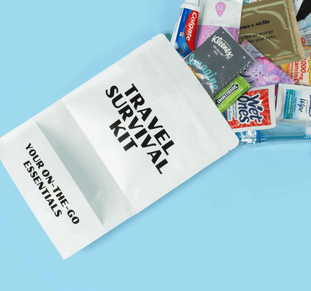A travel survival kit bag on a blue surface with various items such as tissues, wipes, toothpaste, gum, and snacks partially visible&mdash;perfect as thoughtful flight attendant gifts for those always on the go.
