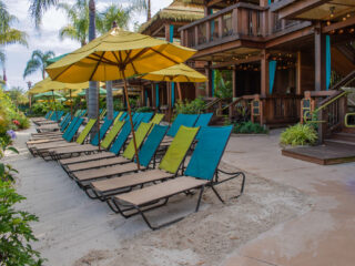 private cabanas next to row of lounge chairs at Volcano Bay water park in Orlando