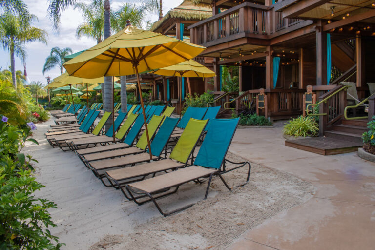 private cabanas next to row of lounge chairs at Volcano Bay water park in Orlando