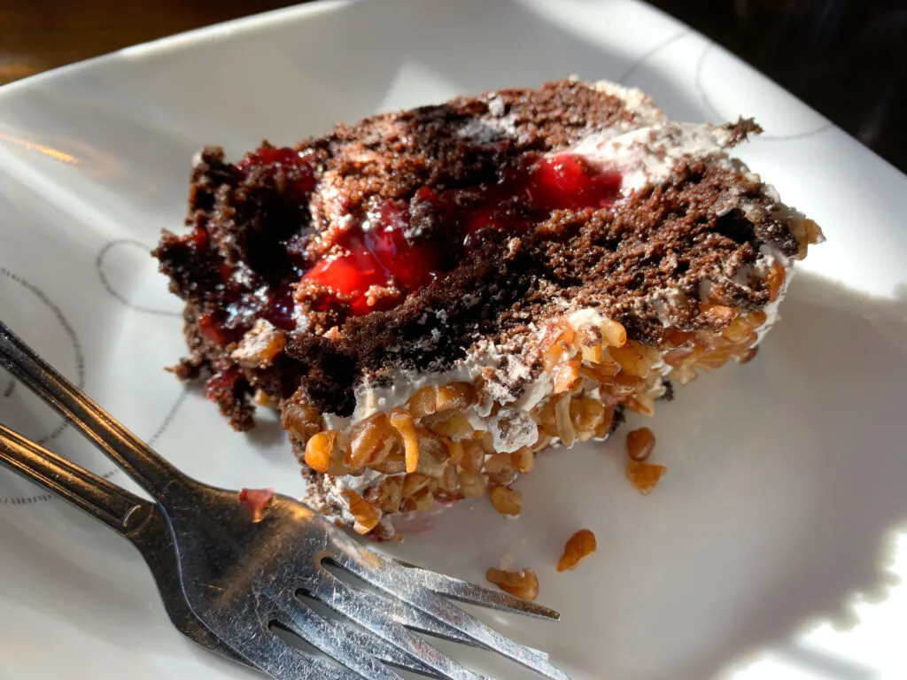 slice of black forest cake on a white plate with two forks