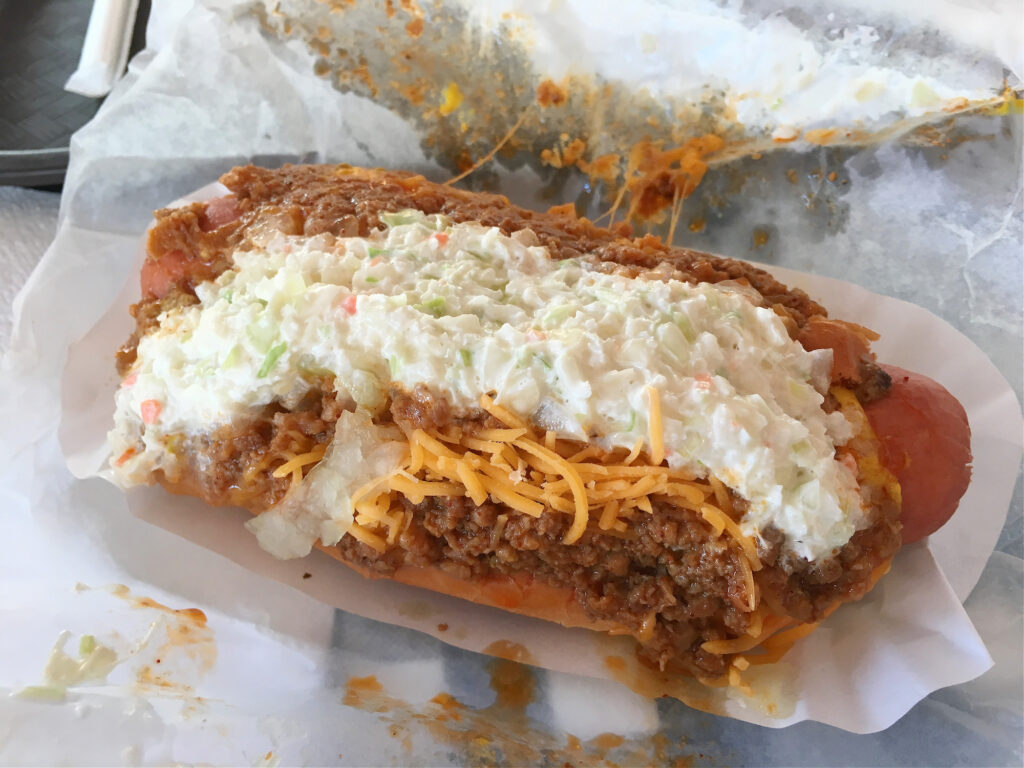 hot dog topped with chili, cheese and coleslaw