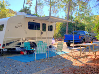 small RV and blue truck parked in a campsite at Disney Fort Wilderness RV resort