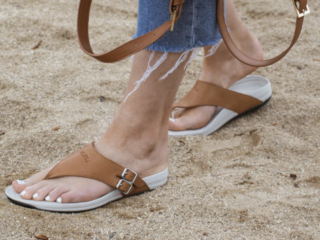 woman wearing KURU sandals on sandy beach