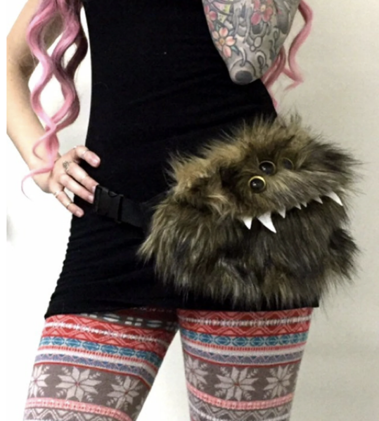 woman wearing a fuzzy monster hip bag