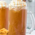 glass mug filled with butterscotch beverage and topped with whipped cream drizzeled with butterscotch sauce