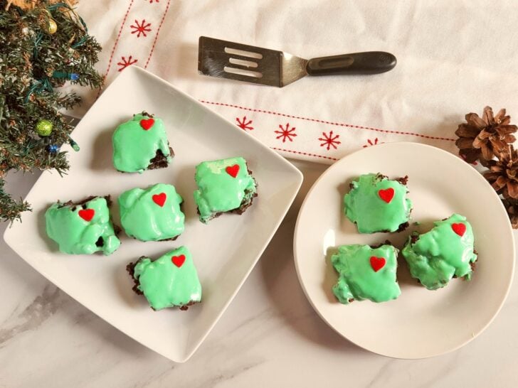 brownies on a plate covered in green icing and a red heart candy