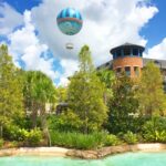 Hot air balloon over Disney Springs and bright blue lagoon in foreground