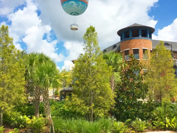 Hot air balloon over Disney Springs and bright blue lagoon in foreground