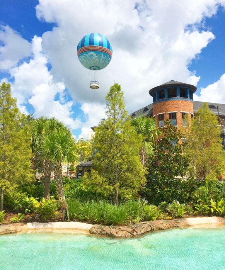 Hot air balloon over Disney Springs and bright blue lagoon in foreground