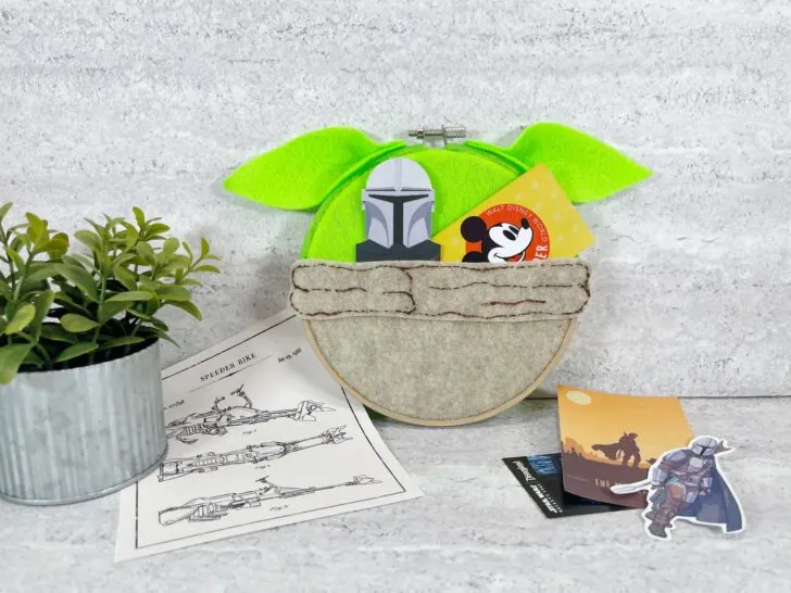 finished Yoda hoop craft with Star Wars memorabilia and a small house plant with a gray background