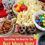 wooden charcuterie board topped with candies and movie theater snacks displayed on a white counter top