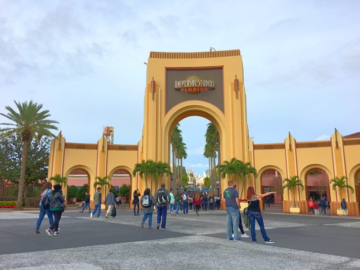 people standing outside the main entrance to universal studios florida theme park