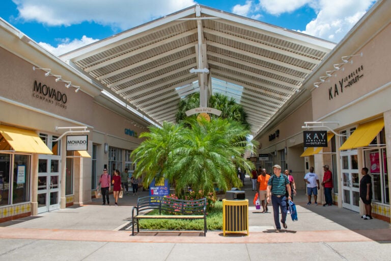 people walking in sidewalks at outdoor outlet mall in orlando