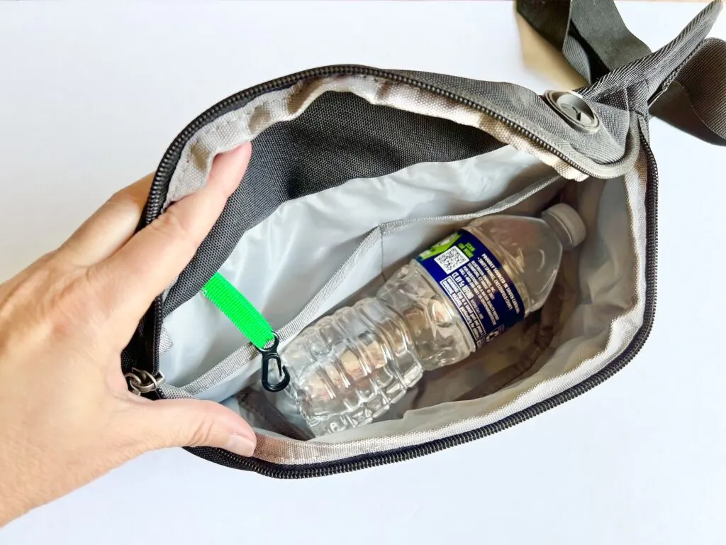 interior of black fanny pack with a water bottle inside