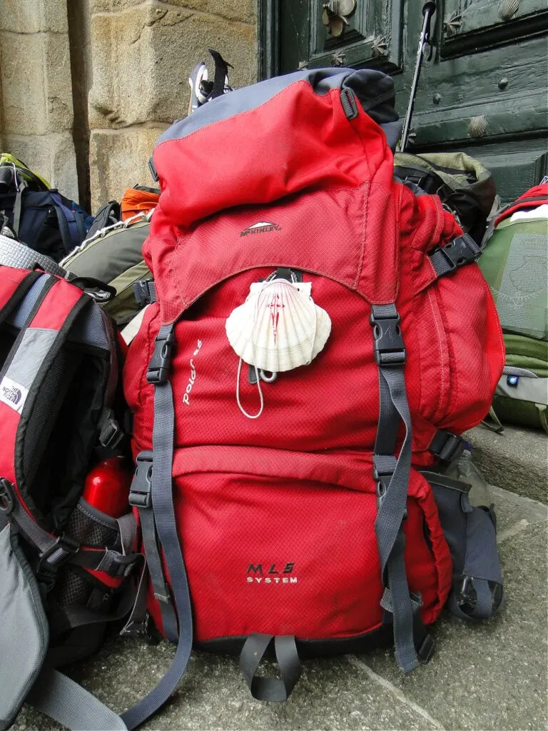 A red backpack is sitting on the ground in Spain.