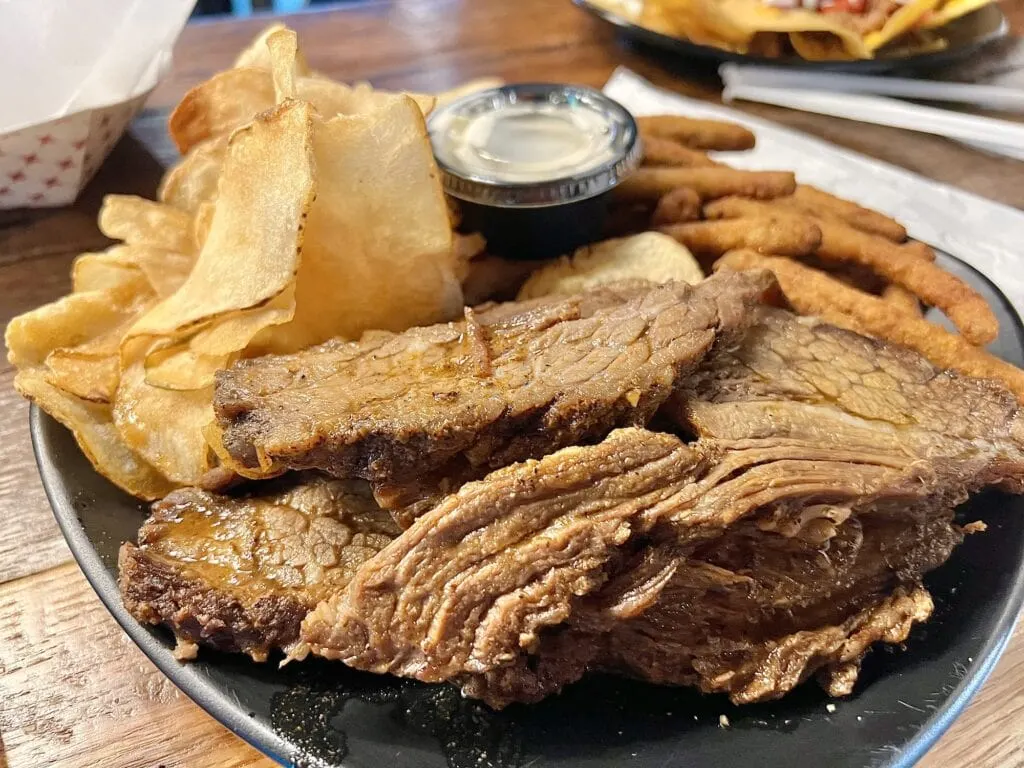 A plate of meat and chips on a table