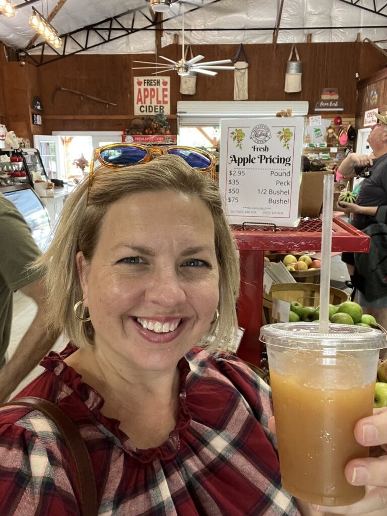 A woman holding a cup of apple juice at a market in Asheboro.