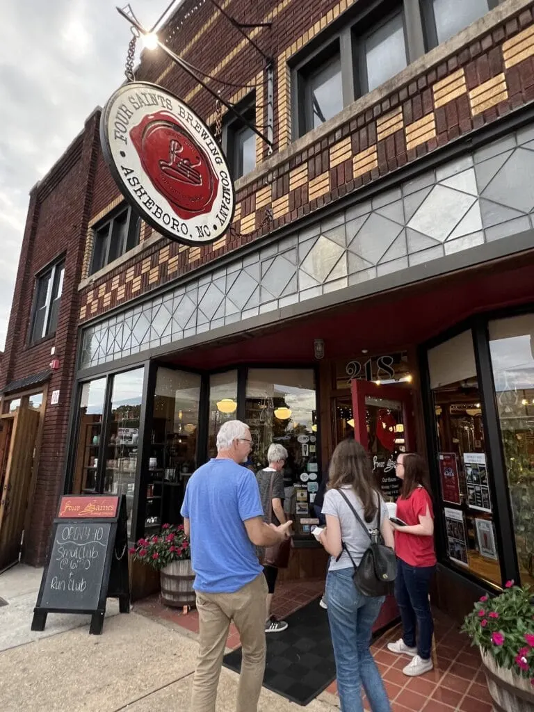 A group of people standing outside of a restaurant, enjoying one of the popular things to do in Asheboro.