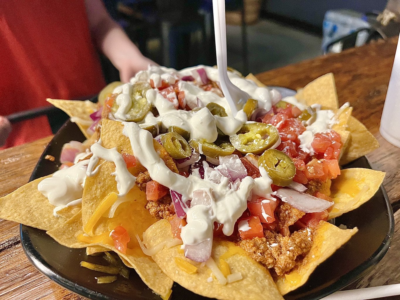 plate of loaded nachos with white fork sticking up