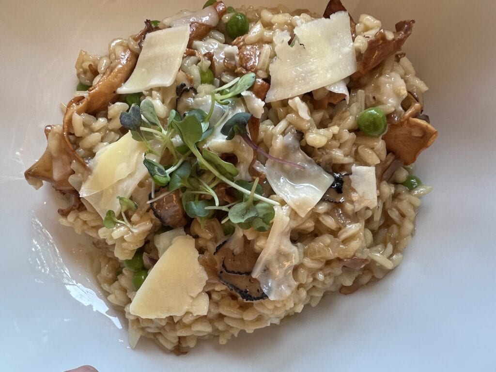 Risotto with mushrooms and peas in a white bowl served at The Henderson.